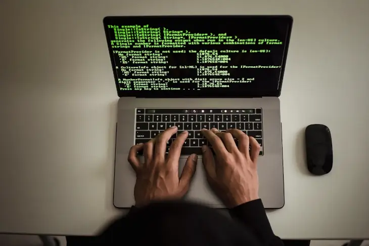 Développeur sans visage travaillant sur du code logiciel sur un ordinateur portable